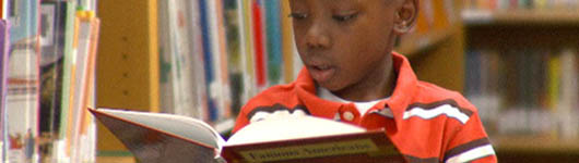 Young black man reading book.